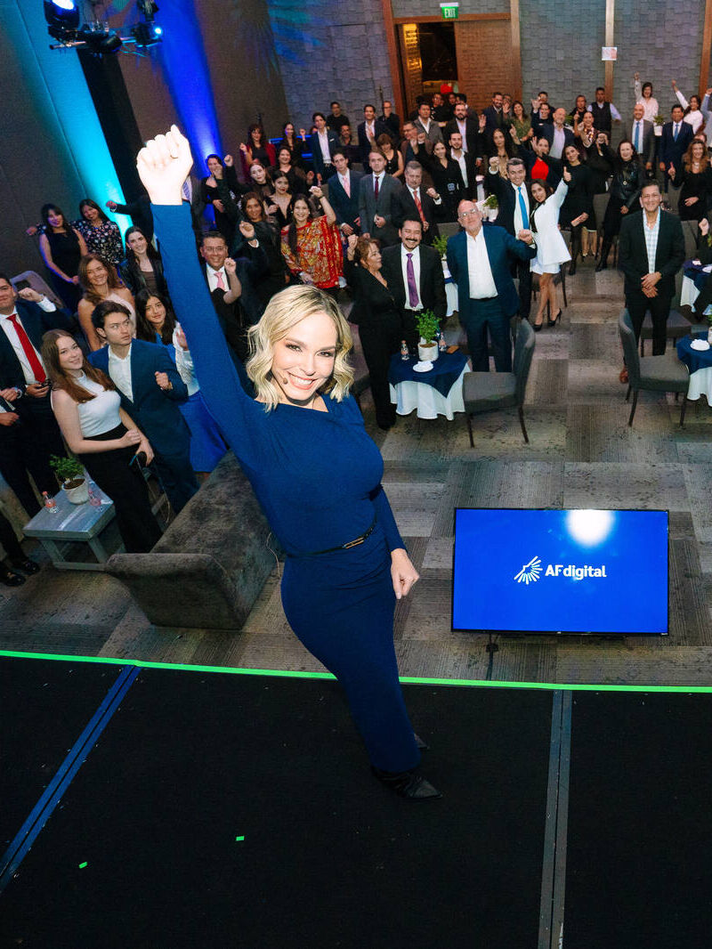 Conductora celebra con la audiencia al cierre de un evento corporativo