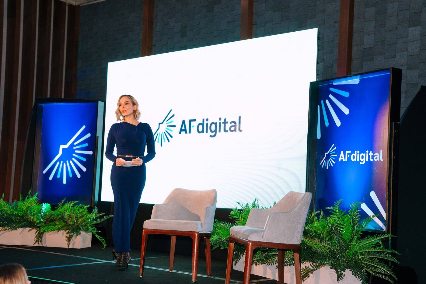 Conductora en el escenario de un evento corporativo