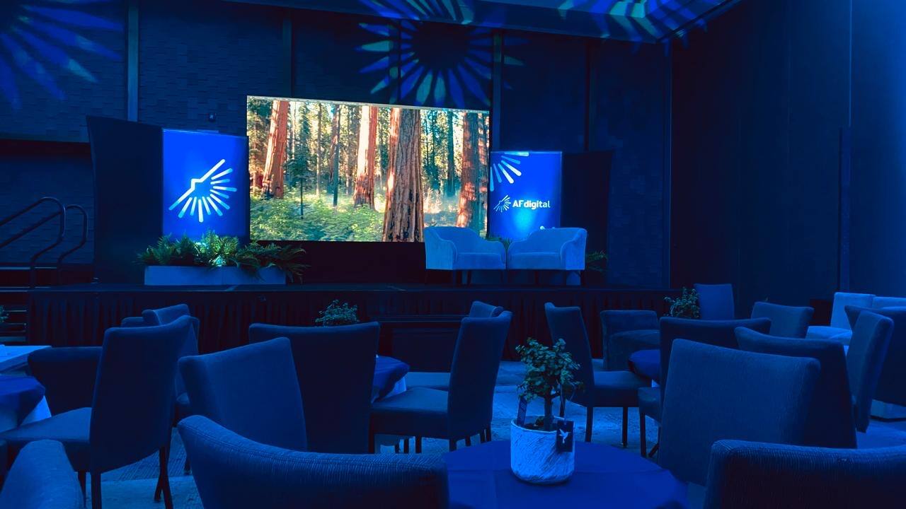 Venue montado en azul con sillas lounge y pantalla